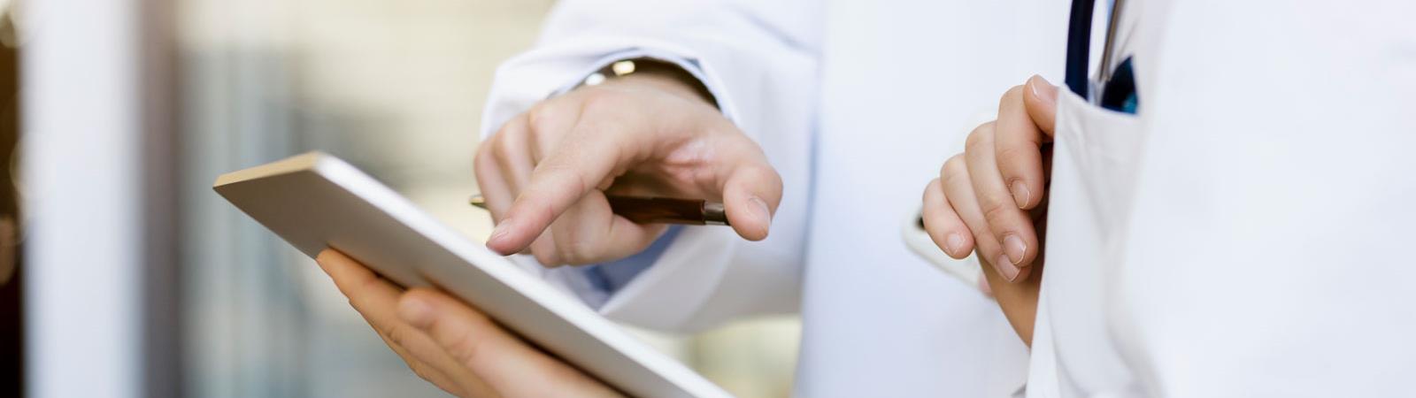 Doctor hands on tablet